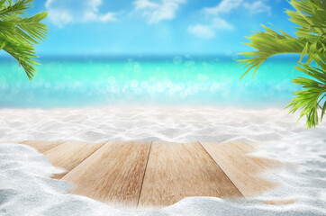 Beautiful nature green palm leaf on tropical beach with bokeh sun light wave and wooden table top on white sandy beach montage photo for product advertisement display