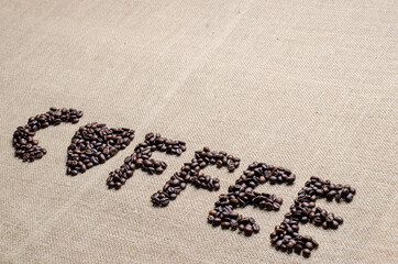 The coffee beans used to spell inscription coffee and a heart on hessian sack, Love coffee concept.