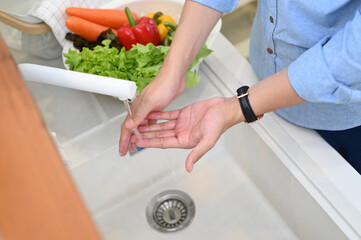 Close up shot of man washing and cleaning his hand before and after make food in kitchen.