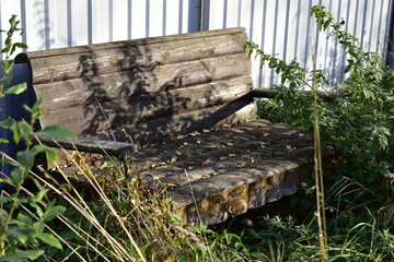 bench made of wooden boards overgrown with grass