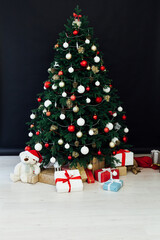 Fototapeta na wymiar Christmas tree pine black interior room new year decor garland gifts postcard