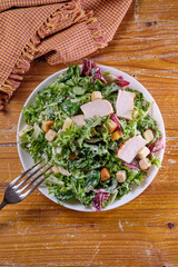 Plate of traditional Caesar salad with chicken and cheese