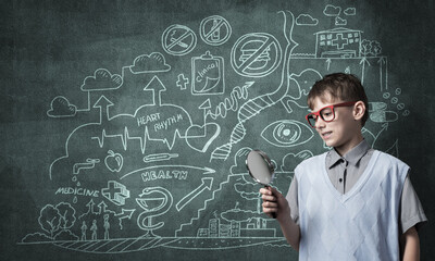 Curious school boy with magnifier