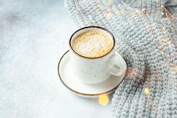 Obraz na płótnie Canvas Cup of coffee, scarf and garland. Cozy autumn or winter composition. Scandinavian style