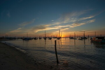 Fototapeta premium sunset, water, sky, sea, sun, lake, sunrise, landscape, beach, ocean, pier, nature, clouds, evening, reflection, dusk, travel, calm, river, boat, silhouette, orange, boats, horizon, blue