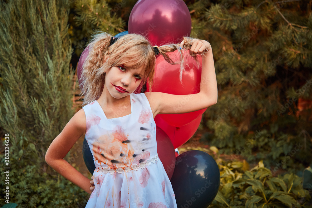 Wall mural one girl aged 9 in a halloween dress with red and black balloons in the open air in the park, emotio