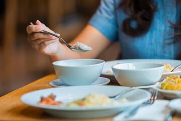 Close up image of young woman eating Boiled rice with pork , Classic breakfast a tasty omelet and fresh juice oranges. This energy boost for the whole day.