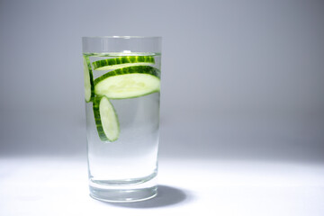 Glass cup with water and cucumber slices