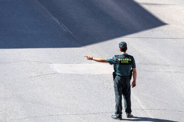 A Spanish Civil Guard points out the direction of traffic