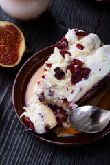   piece of cake with berries and tasty ripe purple  fig on black wooden table.  close up. life style concept