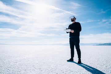 Unrecognizable man using tablet in VR goggles