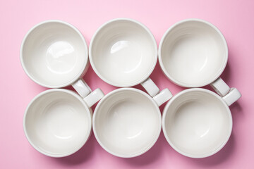 White cups on a pink background. Lots of empty tea cups.