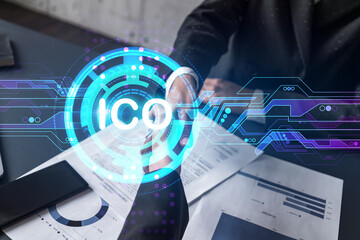 Double exposure of two businesspeople handshake and initial coin offering, ICO hologram drawing...