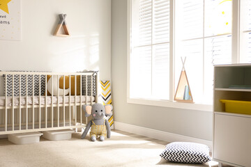 Cute baby room interior with crib and big window