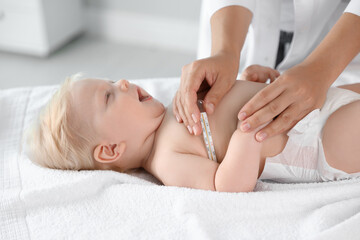 Pediatrician checking baby's temperature in hospital, closeup. Health care