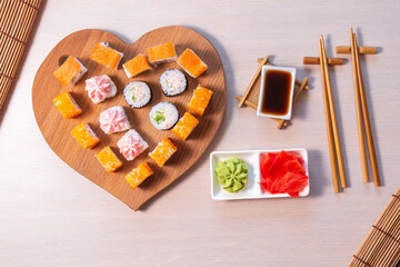 valentines day. Rolls stacked, soy sauce and sticks