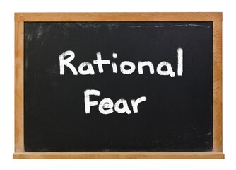 Rational Fear written in white chalk on a black chalkboard isolated on white