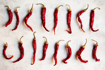 Pimientos rojos secos puestos en linea sobre un fondo blanco