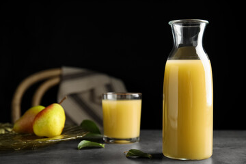 Fresh pear juice in glass bottle on grey table
