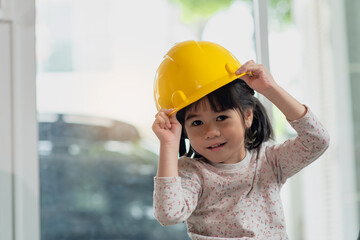 Little Asian girl engineer wearing helmet, education and occupation concept