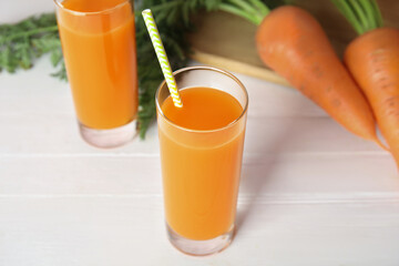 Freshly made carrot juice on white wooden table