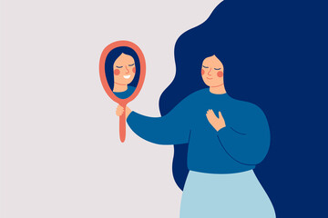 Young woman looks at the mirror and sees her happy reflection. Self-acceptance and confidence concept.