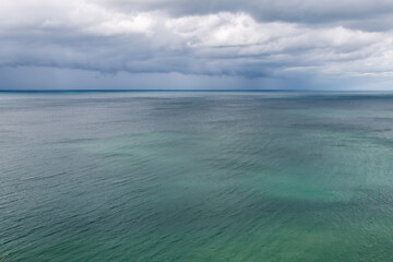 Fototapeta na wymiar leuchtend grün blauer Ozean mit Wolken am Horizont