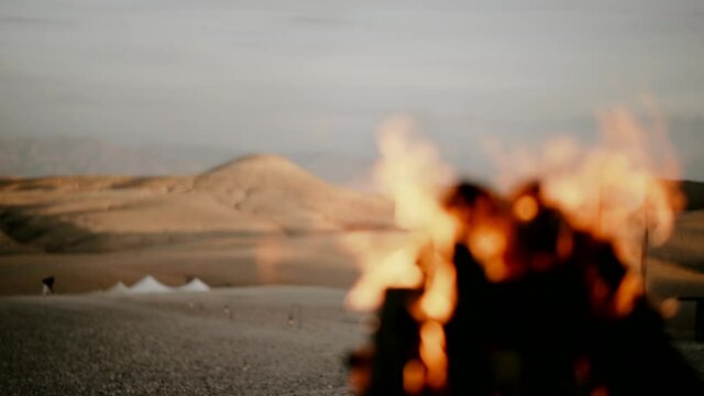 Bonfire in desert shifting focus in morocco afgay luxury camp