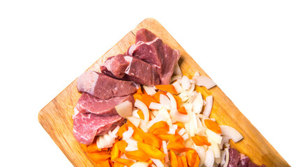 Pork meat cut into pieces with carrots and onions on a cutting Board on a white background with a place for writing,side view