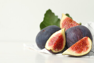 Whole and cut tasty fresh figs on white table, closeup. Space for text
