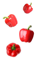 Red bell peppers falling on white background
