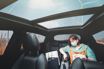  asian woman shopping by drive thru and wear protective mask with wind turbine outdoor