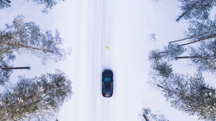 Aerial view from drone of car stopping to pick up hitchhiker explore wild destinations on journey, bird’s eye view of one person get into transport discover north cold lands on road trip in winter.