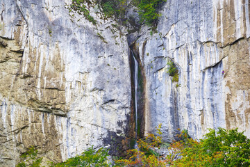 Summer in the mountains. Waterfall over a rock wall. Vanturatoarea Waterfall in Cernei Mountains