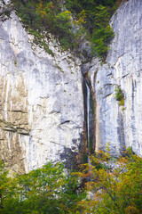 Summer in the mountains. Waterfall over a rock wall. Vanturatoarea Waterfall in Cernei Mountains