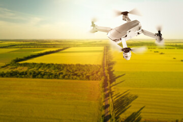 Fototapeta premium Modern drone flying over fields on sunny day. Aerial survey