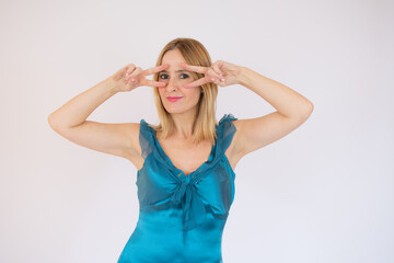 Young celebrating woman blue dress. Beautiful model portrait isolated over studio background