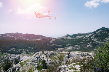 Fototapeta na wymiar Airplane flying over beautiful mountains on sunny day
