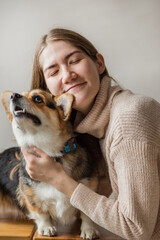 Happy european woman in jacket holding corgi pembroke dog