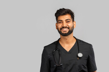 young indian male doctor or surgeon with stethoscope on gray background