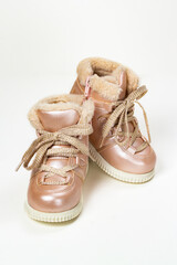 child winter boots with laces and fur for girls, artificial pink leather and lurex laces, vertical photo. Beautiful shoes for a child, warm boots