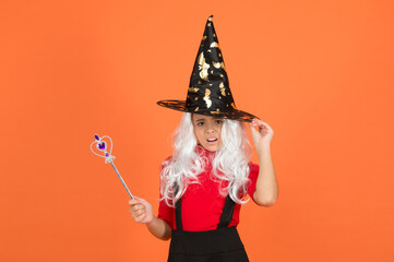 happy halloween. smiling child in witch hat. kid hold magic wand. childhood happiness. teen girl...
