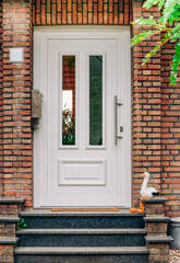 Fototapeta na wymiar Baby announcement - Front door with white stork sitting on doorstep