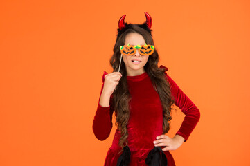 real witch in disguise. child with funny party attribute. teen girl has curly hair wear dress for holiday celebration. autumn season holidays. childhood leisure. happy halloween. kid wear devil horns