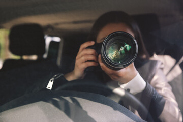 Private detective with camera spying from car - obrazy, fototapety, plakaty