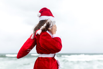 Obraz premium little girl in santa suit on the beach