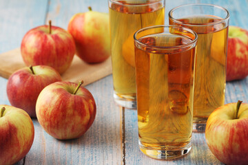 Glasses with apple juice and ripe apples
