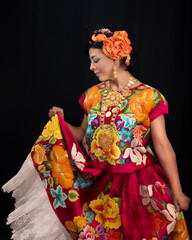 bailarina mexicanan de oaxaca mexico, usando traje de la region del istmo de tehuantepec, baila en la guelaguetza de, con fondo negro y un vestido bordado a mano, porta corazon de amor a mexico