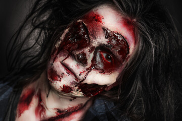 Scary zombie on dark background, closeup. Halloween monster