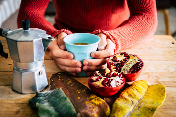 Fototapeta na wymiar Young people do breakfast at home with coffee in autumn composition background concept - red and yelow colors and female holding cup of coffee on a wooden table